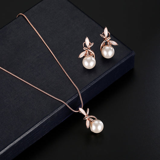 Rose gold-toned necklace and matching earrings set with white pearls and a delicate floral or leaf design. - Image 11