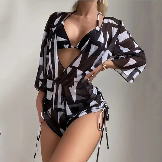 Woman wearing a white and black tie-dye beach cover-up romper with a deep V-neck and drawstring sides.