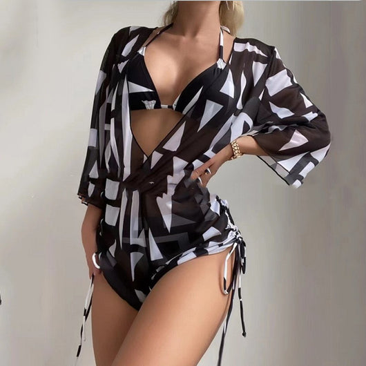 Woman wearing a white and black tie-dye beach cover-up romper with a deep V-neck and drawstring sides.