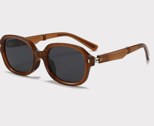 Brown oval sunglasses with dark lenses and thick frames, featuring visible silver hinges on a light gray background. - Image 18