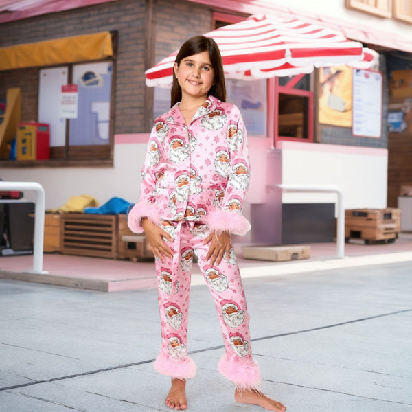 Young girl in a leopard print pajama set with black feather trim on the cuffs and ankles, wearing a pink glitter headband.
