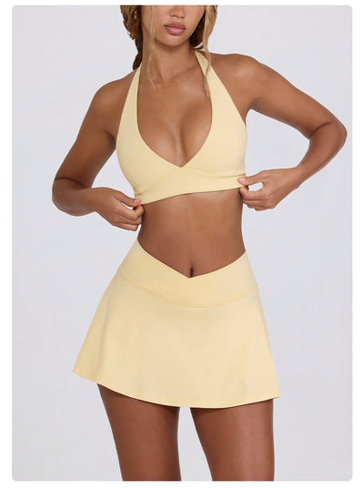 Light pink halter neck sports bra and high-waisted leggings workout set on a model. - Image 48