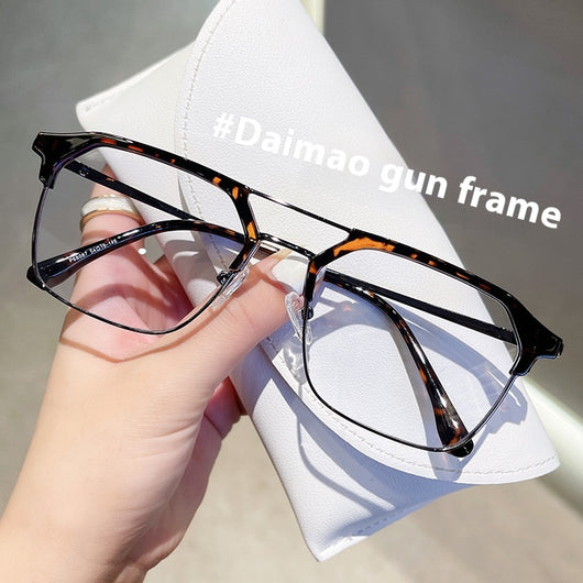 Anti-blue light glasses with a sand black and silver double beam frame, held against a white case. - Image 10