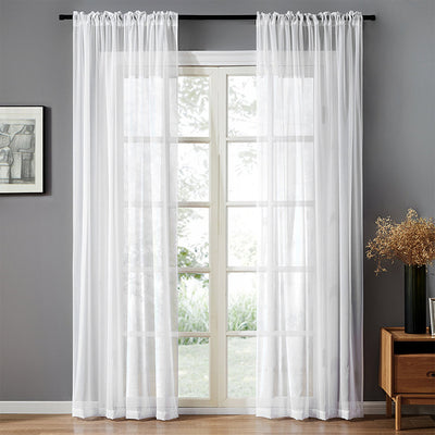 Sheer pink rod pocket curtain hanging on a black curtain rod, offering light transmission for a modern room.