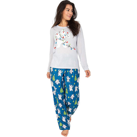 Family of four wearing matching Christmas pajamas with polar bears, string lights, and Christmas trees. - Image 3