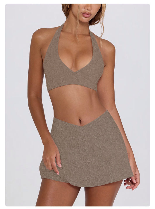 Light pink halter neck sports bra and high-waisted leggings workout set on a model. - Image 37