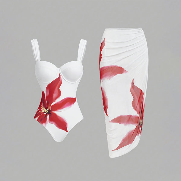 White one-piece swimsuit with red floral print and matching ruched sarong skirt for beach or resort wear.