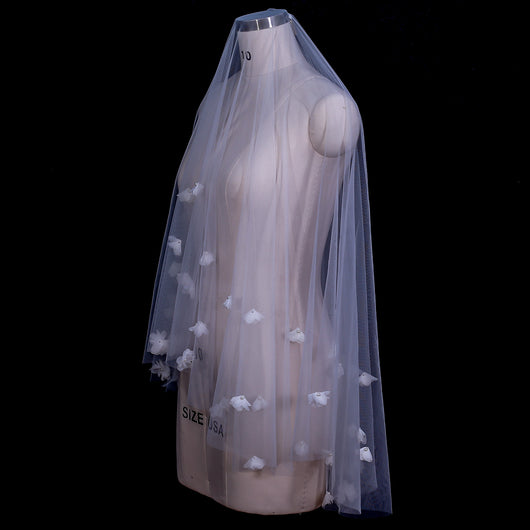 White and ivory sheer fabric swatches for a wedding veil displayed on green grass. - Image 9