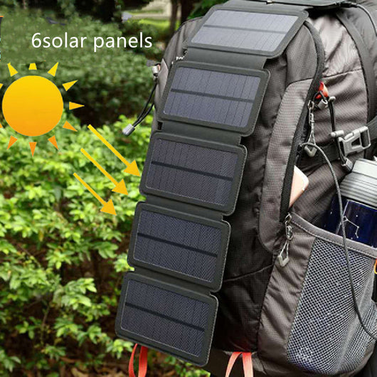 Black portable folding solar panel charger with six panels attached to a backpack in an outdoor setting. - Image 10