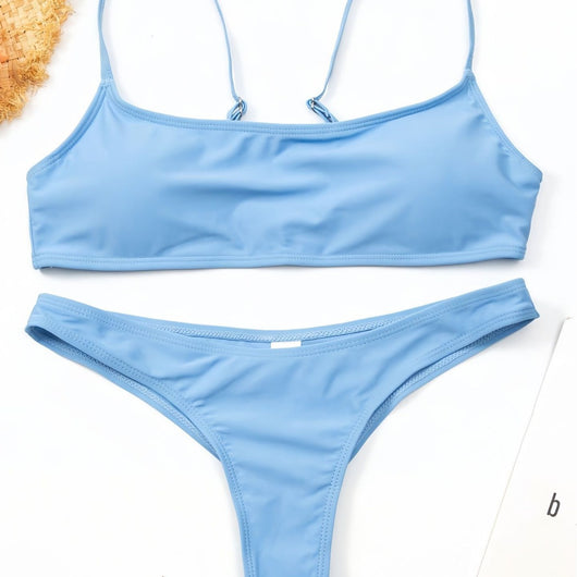 Women's casual orange textured bikini set with scoop neck top and high-cut bottoms against a stone wall. - Image 3