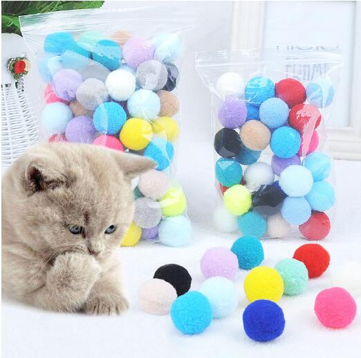 Assortment of colorful plush pom-pom balls, some in a wooden box, others scattered on a white surface. - Image 8