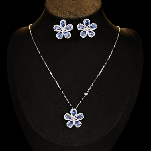 Elegant jewelry set with a silver-tone necklace and matching stud earrings, featuring blue and clear floral gemstones. - Image 4