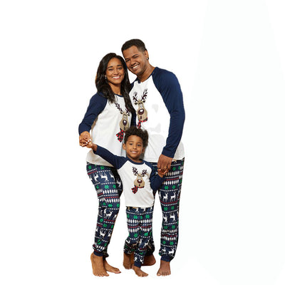Family of three wearing matching Christmas pajamas with reindeer tops and snowflake-patterned pants. - Image 9