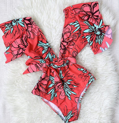 Coral one-piece swimsuit with deep V-neck, ruffled sleeves, and tie-front waist, featuring pink and teal floral print. - Image 2