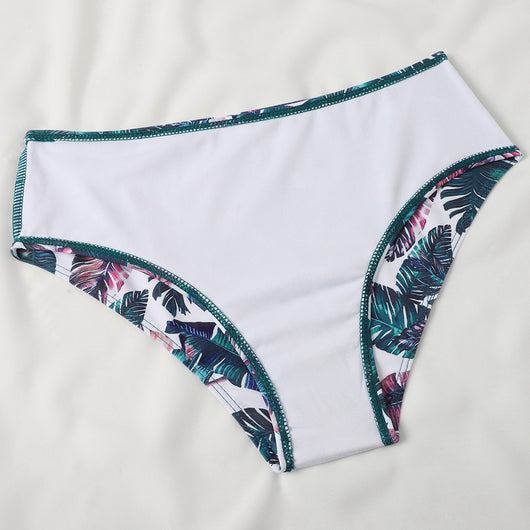 Teal twisted bandeau bikini top with tropical leaf print high-waisted bottoms on a model wearing a white shirt. - Image 20