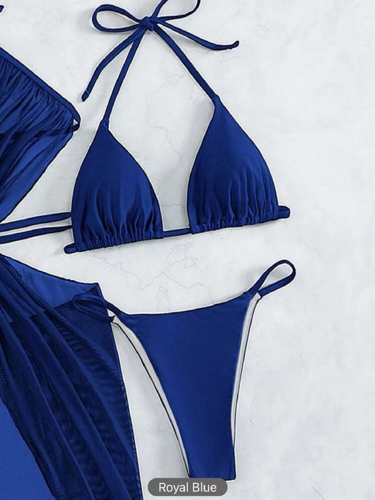 White three-piece halter neck bikini and sheer cover-up set with a heart-shaped embellishment, laid flat on wood. - Image 18