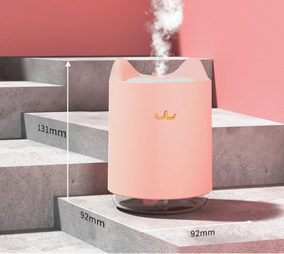 White mini USB humidifier with cat ears and a gold cat nose/mouth emblem, featuring a clear water tank base. - Image 6