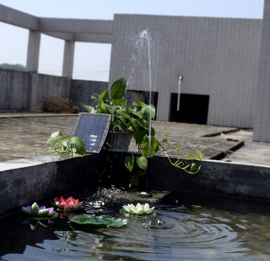 5W solar fountain kit with black solar panel on a ground stake, water pump, coiled hose, and various nozzles. - Image 17