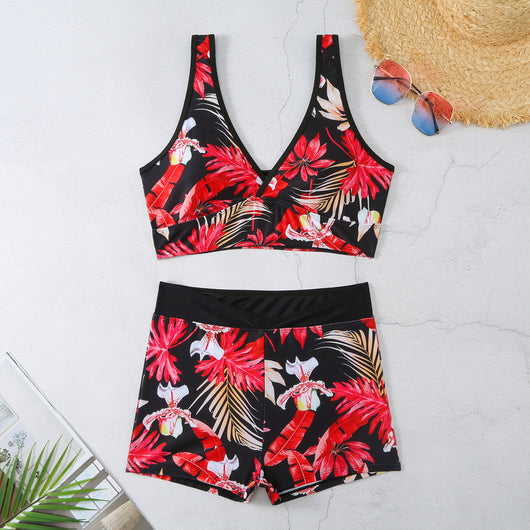 Two-piece swimsuit with a black background and vibrant pink and purple tropical floral print. Features a V-neck crop top and high-waisted boxer shorts. - Image 11
