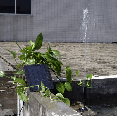 5W solar fountain kit with black solar panel on a ground stake, water pump, coiled hose, and various nozzles. - Image 20