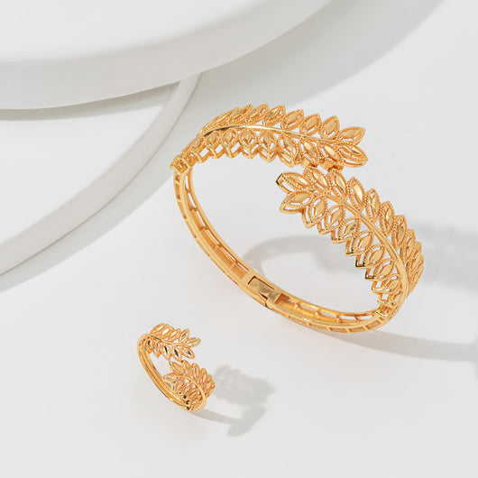 Gold wheat ear leaf cuff bracelet and matching open ring set on a white textured surface. - Image 3