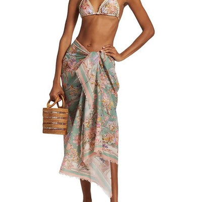 Women's green and pink floral bikini suit with matching sarong. Halter triangle top, tie-side bottoms, and wrap skirt.