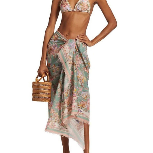 Women's green and pink floral bikini suit with matching sarong. Halter triangle top, tie-side bottoms, and wrap skirt.
