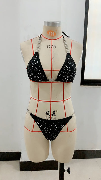 Black two-piece bikini with rhinestone chain halter straps and connectors, laid flat on white faux fur. - Image 11