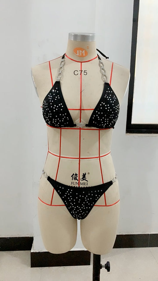 Black two-piece bikini with rhinestone chain halter straps and connectors, laid flat on white faux fur. - Image 11