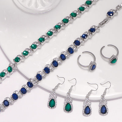 Light luxury jewelry set with silver-tone necklace, dangle earrings, open ring, and bracelet, all featuring emerald green teardrop and oval stones with clear rh - Image 11