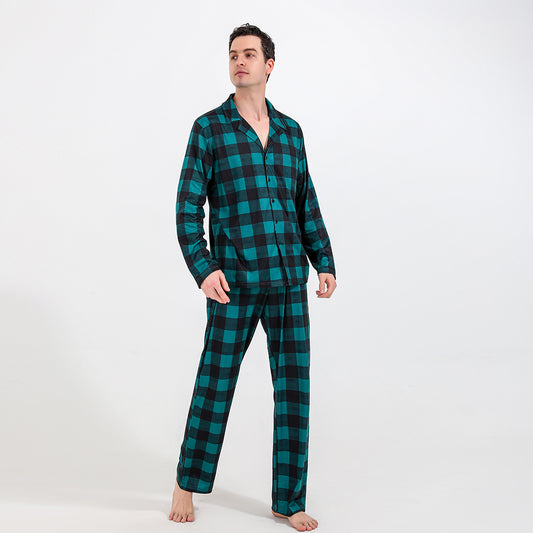 Family of four and dog wearing matching green and black plaid pajamas. Mother and father in two-piece sets, girl in dress, baby in two-piece, and dog in bandana - Image 2