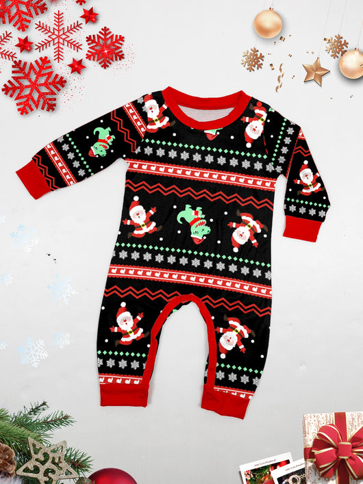 Man wearing black Christmas pajamas with a cartoon dinosaur, Santa Claus, and "Merry Christmas" text, standing by a decorated tree. - Image 32