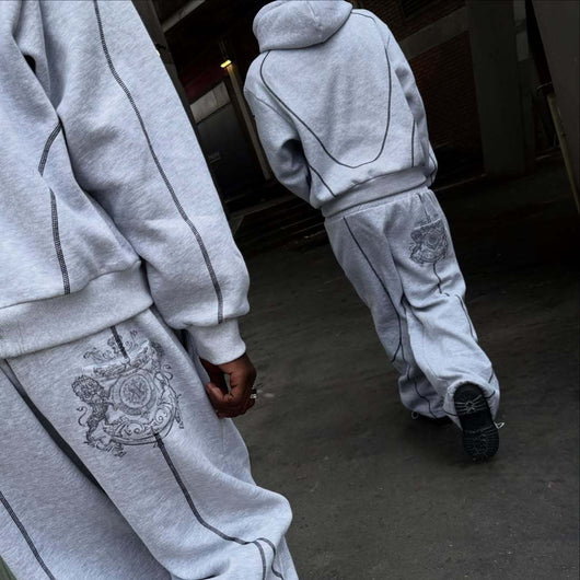 Light gray hooded tracksuit with dark gray contrast stitching, featuring a full-zip hoodie and matching loose sweatpants. - Image 4