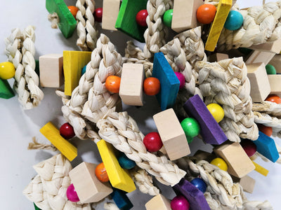Colorful bird toy made of natural wood blocks, beads, and corn husk strips, with a red and green macaw. - Image 8