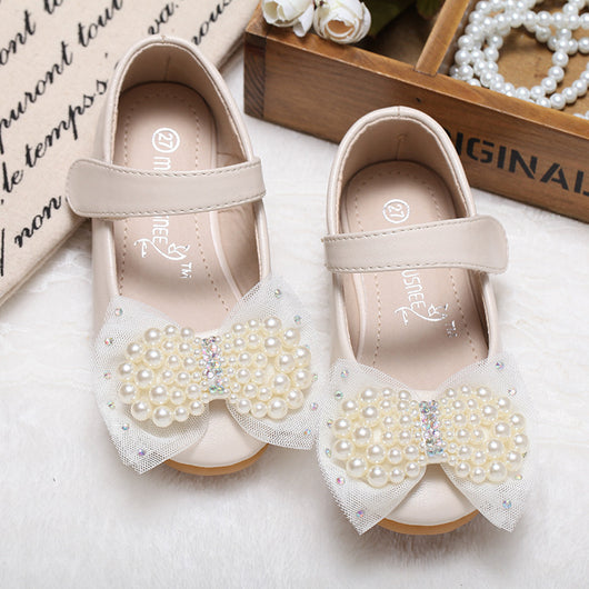 Beige girls' princess shoes with pearl and rhinestone bows, featuring a flat heel and a convenient Velcro strap.
