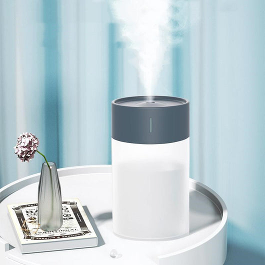 Cylindrical humidifier with a frosted white body and a light pink top, featuring a small mist outlet. - Image 12