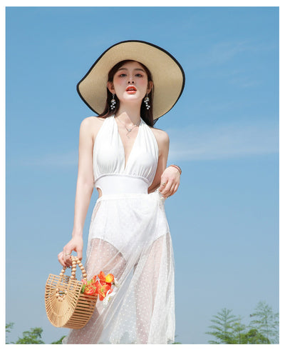 Woman in a white backless halter swimsuit with a sheer polka dot cover-up skirt, straw hat, and bamboo bag. - Image 27