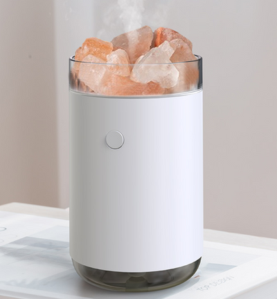 Pink cylindrical humidifier and essential oil diffuser with glowing orange crystal salt stones and a clear base. - Image 7