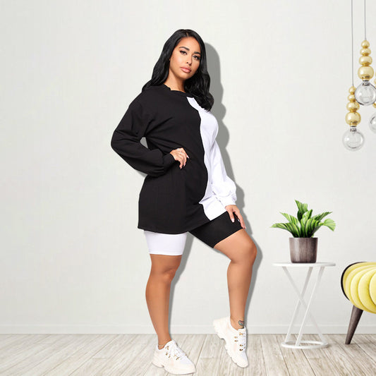 Woman wearing a black and white color-block long-sleeve top and matching shorts with white sneakers.