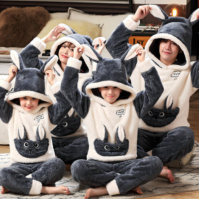 Family wearing matching black and white panda plush housewear suits with hoods and checkered pants, posing indoors. - Image 8
