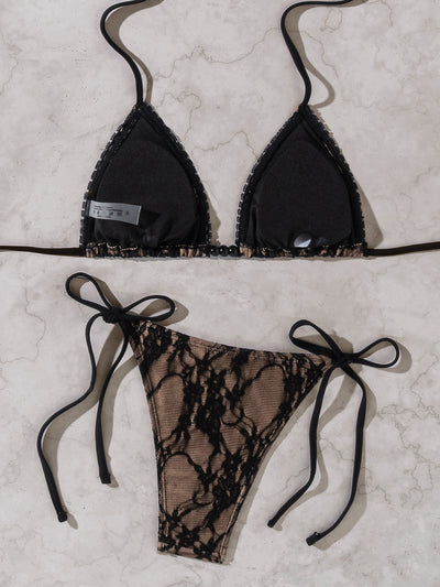 Black lace triangle-cup tie-front bikini swimsuit with nude lining, shown flat on a light marble surface. - Image 15