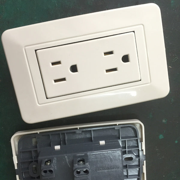 White American standard wall socket with two duplex outlets, providing six holes for electrical plugs.