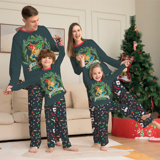 Family of four wearing matching dark green Hogwarts pajamas with a festive Harry Potter pattern, posing by a Christmas tree.