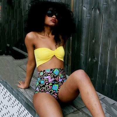 Women's two-piece swimsuit with a solid yellow bandeau top and black high-waisted bottoms with a vibrant abstract geometric pattern. - Image 6
