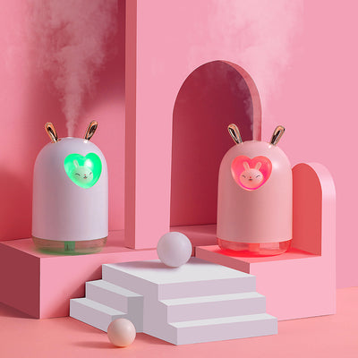 White rabbit humidifier with rose gold ears, a heart-shaped cutout, and a smiling bunny figure inside.