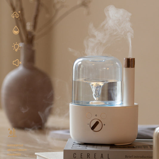 White and clear humidifier with a visible water vortex, emitting mist, and featuring a rose gold accent.