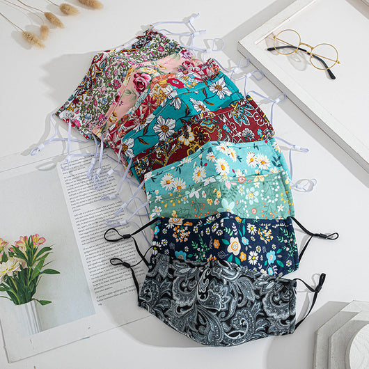 Teal cotton face mask with white floral pattern and brown leaves, featuring adjustable white ear loops. - Image 14