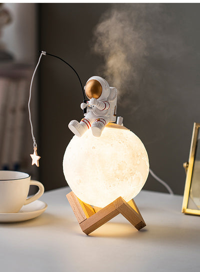 Astronaut figurine sitting on a glowing moon lamp, holding a fishing rod with a star charm, on a wooden stand. - Image 5