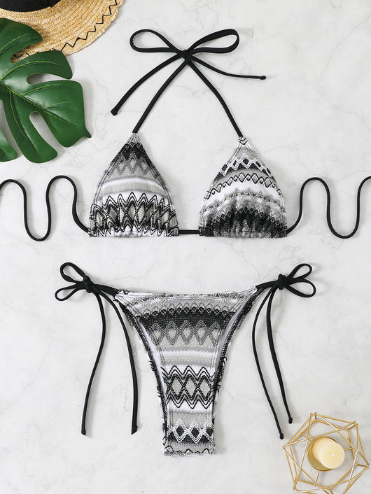 Black and white knitted zigzag bikini with triangle halter top and tie-side bottoms on a marble surface. - Image 9