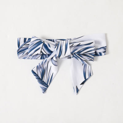 Young boy wearing a white short-sleeve t-shirt with blue tropical leaf print and a black chest pocket. - Image 24